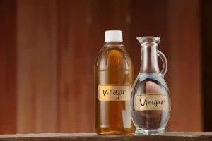 White vinegar on wooden background