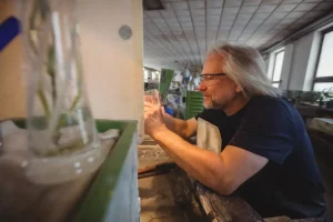 Glassblower polishing and grinding a glassware