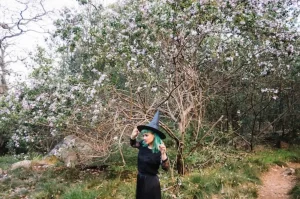 Woman in witch costume posing in forest