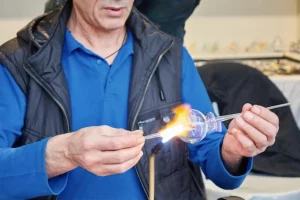 A glass craftsman displays the art of making glassware at street market